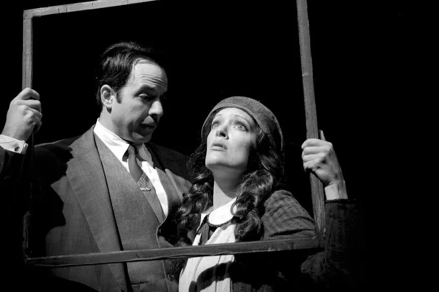 A man holding a frame with a woman inside of it.