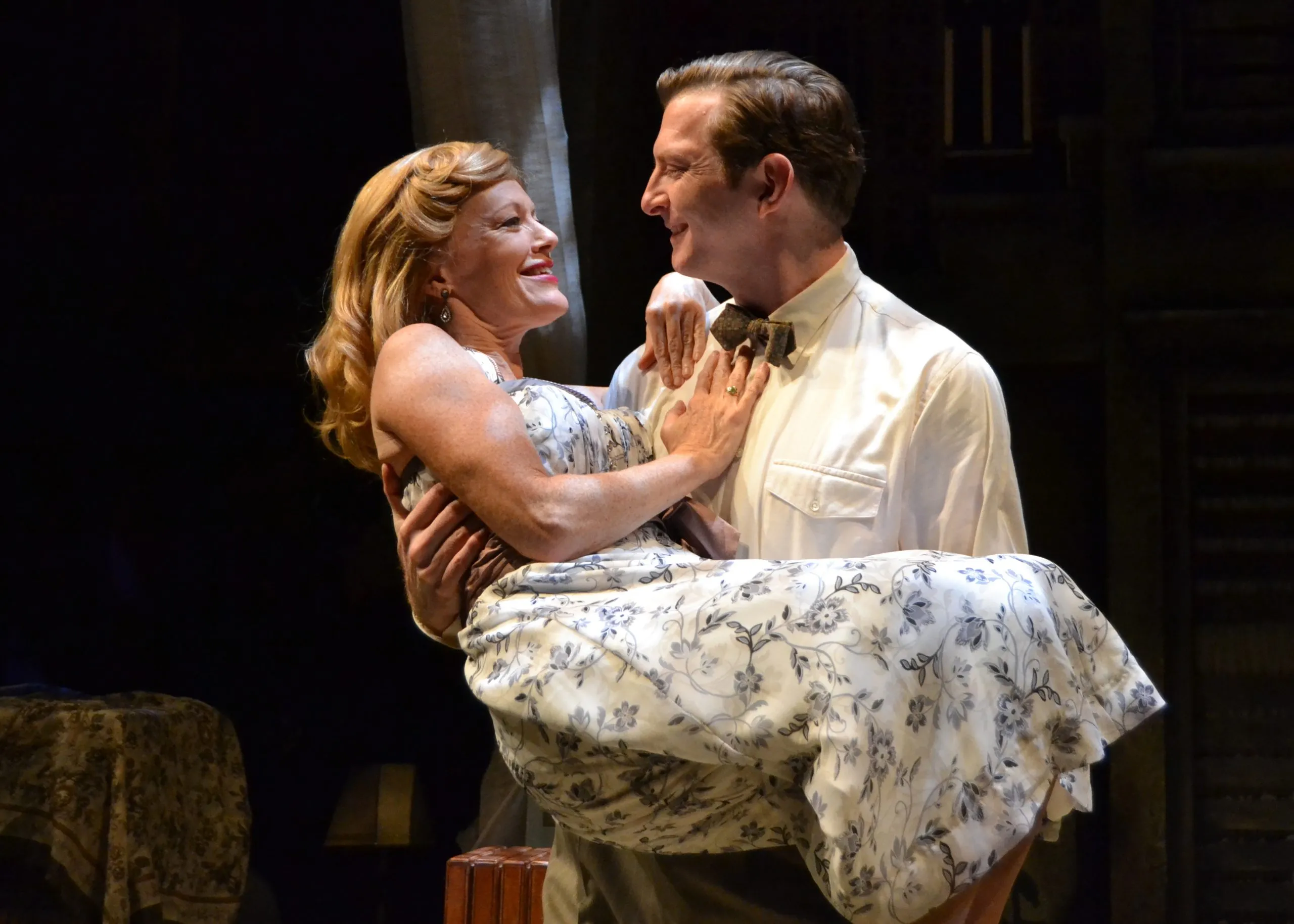 a man wearing a tie holding a woman who is hugging him.